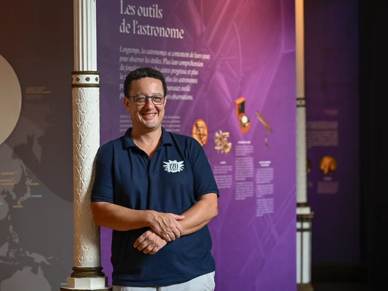 Gaël Potin, directeur du Muséum, discutant avec des visiteurs dans une salle d'exposition lumineuse.
