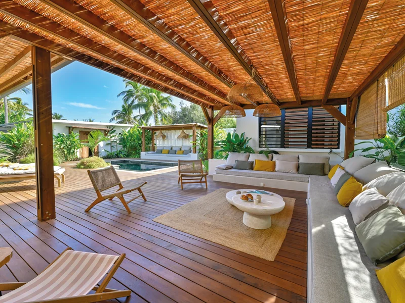 Pergola en bois avec coin salon confortable, idéal pour la sieste ou l'apéritif au coucher du soleil.