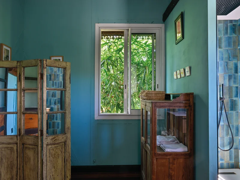 Ancienne photo sépia d'une famille créole devant une case traditionnelle