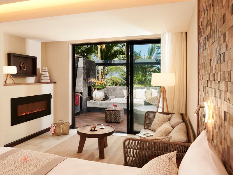 Intérieur luxueux d'une Pool Villa au PALM Hotel & Spa Réunion avec cheminée et bar.