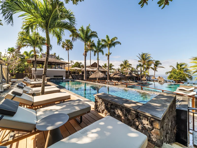 Piscine à débordement avec lits à baldaquin au PALM Hotel & Spa Réunion.