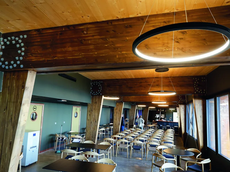 Intérieur chaleureux du restaurant panoramique de l'éco-gîte du Volcan